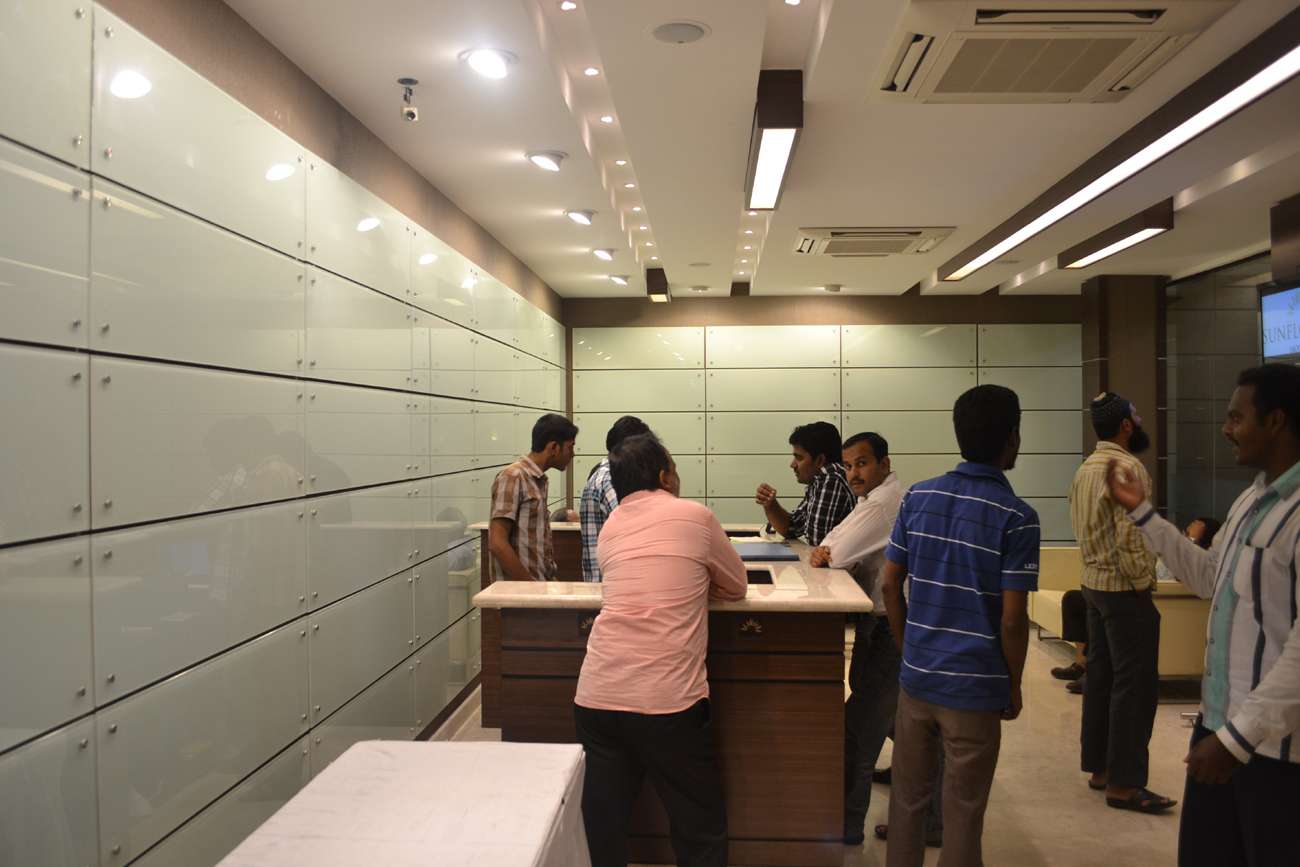 Modern hotel lobby interior in Coimbatore, Tamilnadu, featuring custom-designed reception counters, sleek frosted glass wall panels, recessed lighting, and centralized air-conditioning — designed and executed by hotel interior specialists, turnkey hospitality interior solutions provider.