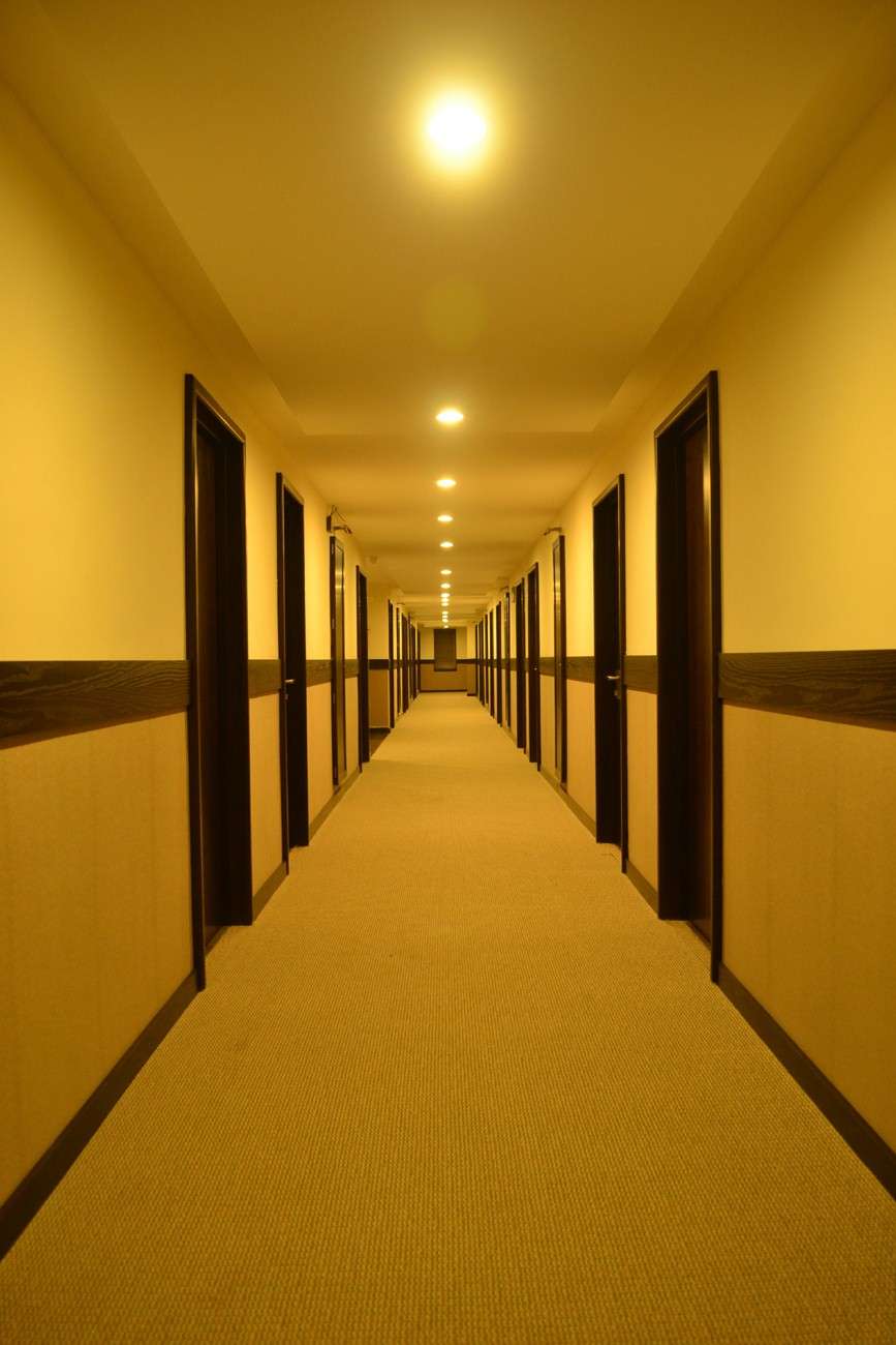 Well-lit hotel corridor interior - room doors supplied and installed by our team — showcasing hotel fit-out work, custom door manufacturing, and turnkey installation services by interior designers and hospitality contractors.