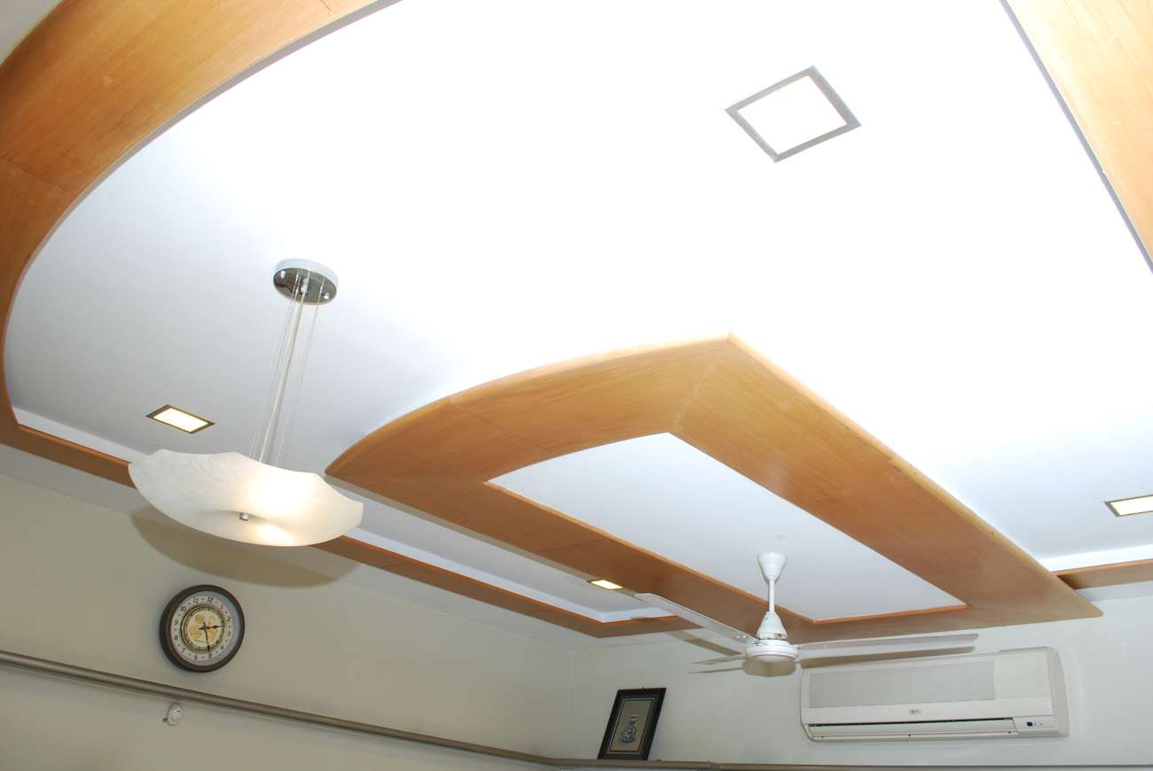 Custom woodwork ceiling design with curved panels and integrated lighting in a bedroom interior at Salem, Tamil Nadu – Designed, manufactured, and installed by our expert interior and furniture team.