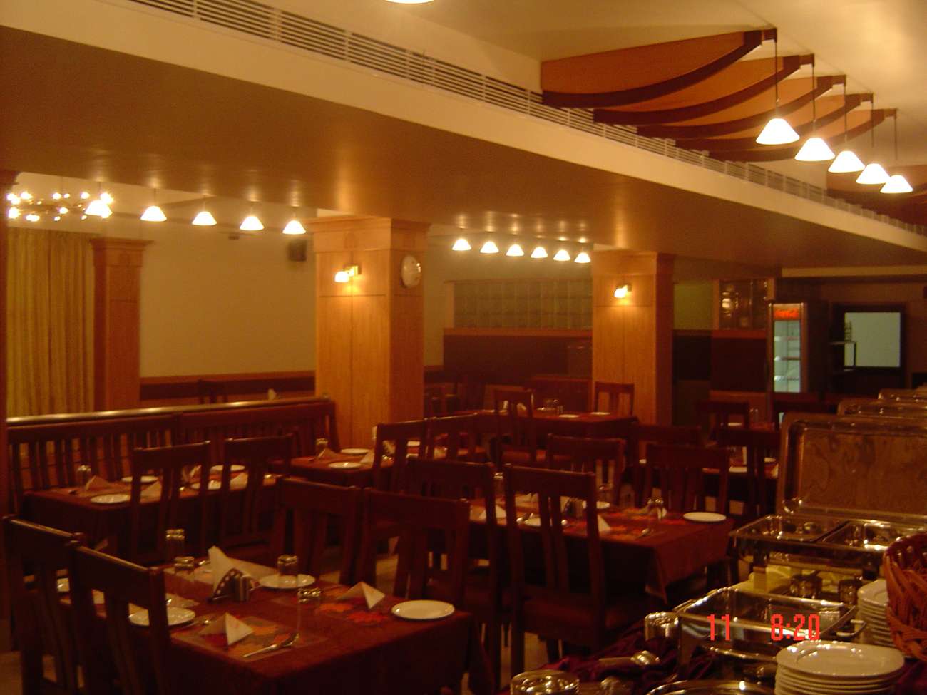 Traditional fine dining restaurant interior with wooden furniture, buffet setup, and warm ambient lighting at a hospitality project in Tamil Nadu—executed by our experienced interior design and contracting team.