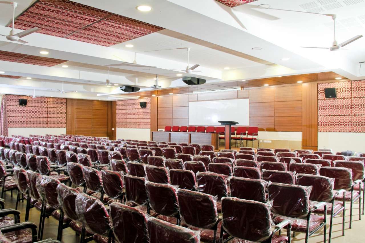 Modern auditorium setup with a podium, stage seating, acoustic ceiling panels, acoustic wall panel- designed by specialists for high acoustic performance in Tamilnadu, India.
