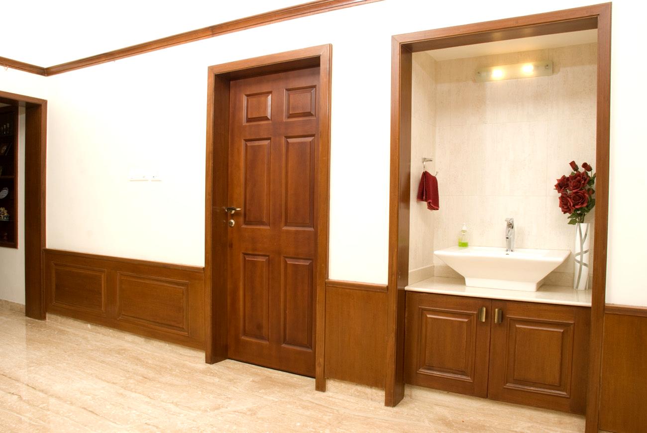 Elegant corridor washbasin unit with classic wooden framing, under-sink storage, and decorative wall paneling, custom designed and executed at a residence in Coonoor near Ooty by interior design and furniture experts