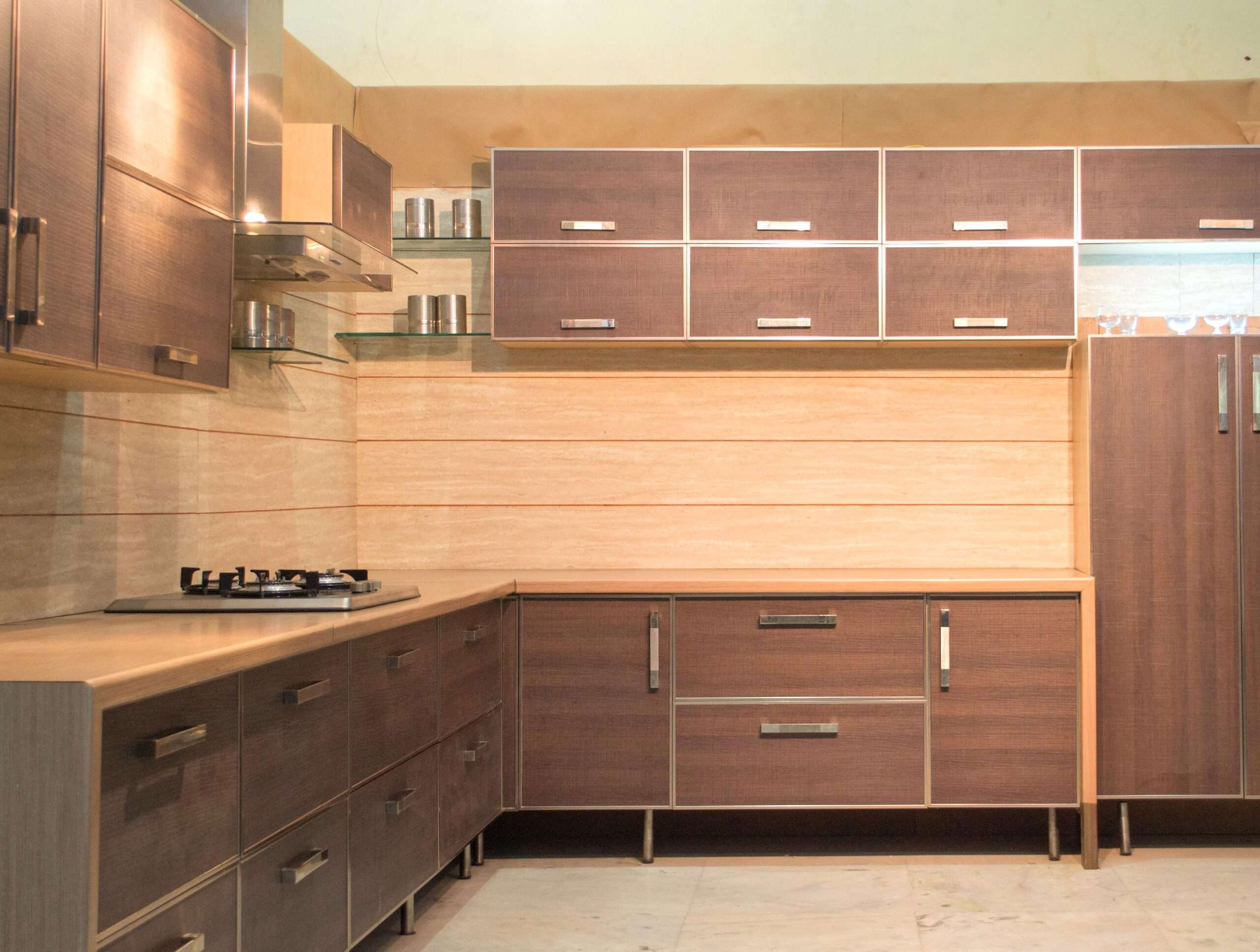 Modular kitchen in Erode with dark wood finish cabinets, aluminum trim and Blum accessories, Fully designed, manufactured, and installed by our expert interior and furniture team.