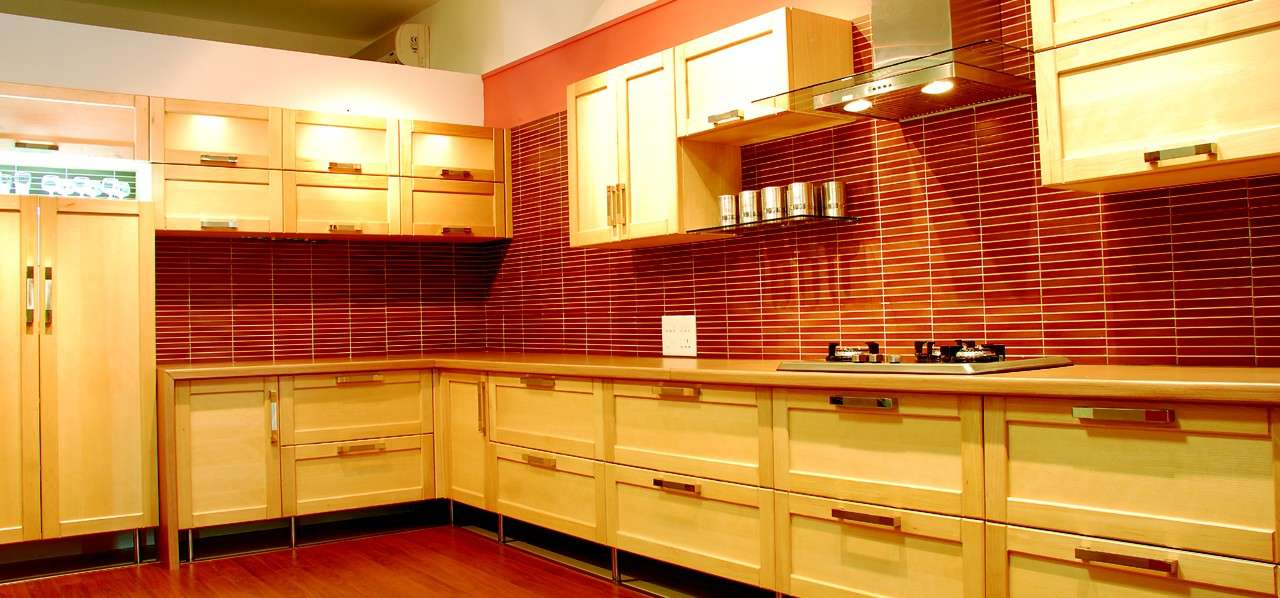 Solid wood modular kitchen in Tiruppur with warm natural finish, abinet lights and contemporary hardware, Fully designed, manufactured, and installed by our expert interior and furniture team.