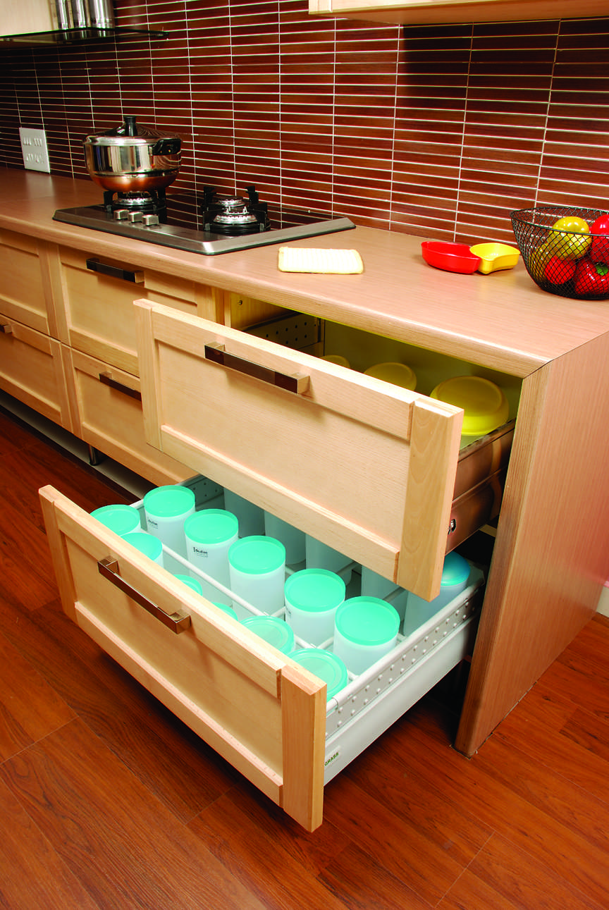 Modular kitchen in Ooty, Tamilnadu with soft-close drawers, in-drawer lighting, and neatly organized storage containers, Fully designed, manufactured, and installed by our expert interior and furniture team.